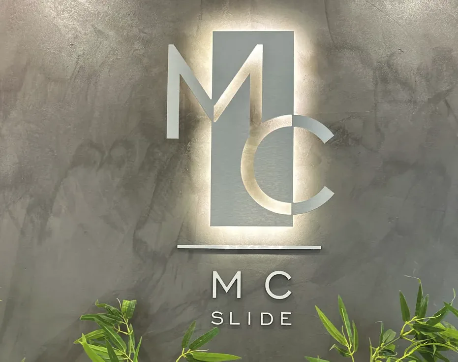 Insegna MC Slide retroilluminata sulla parete in resina dello showroom