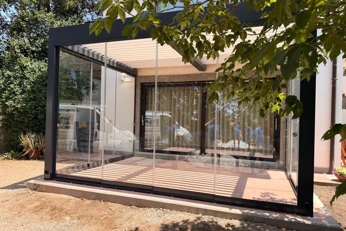 Aluminium pergola with glazed enclosures on all sides, seen from the garden