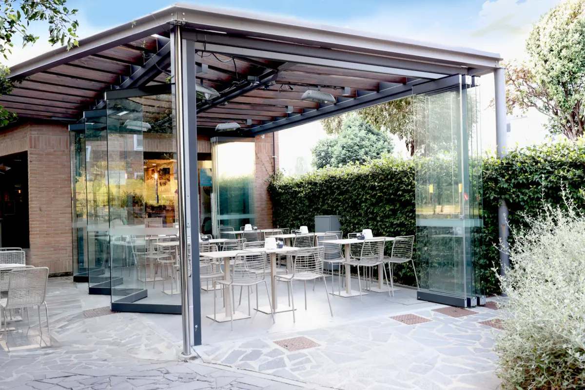 Outdoor dining area of a venue with tables, enclosed by Folding glazing