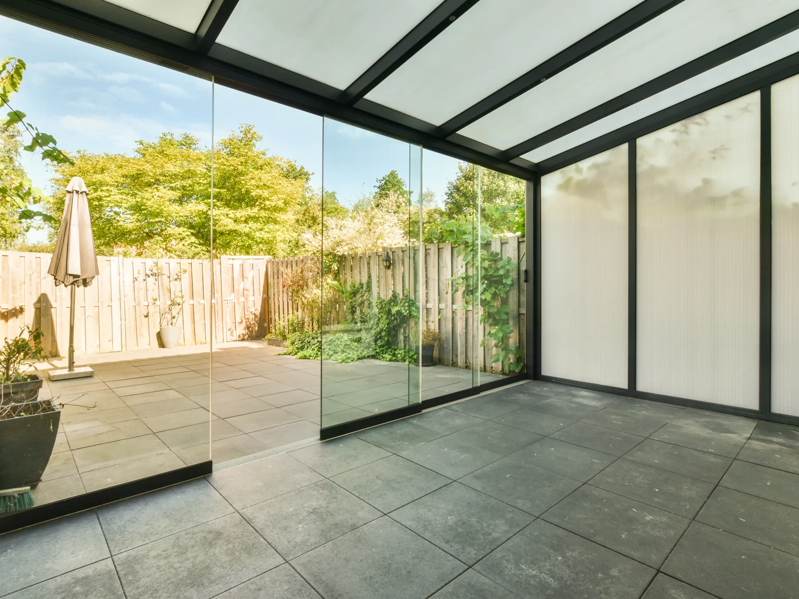 Sliding Floor with white profiles closing the porch on a tiled courtyard