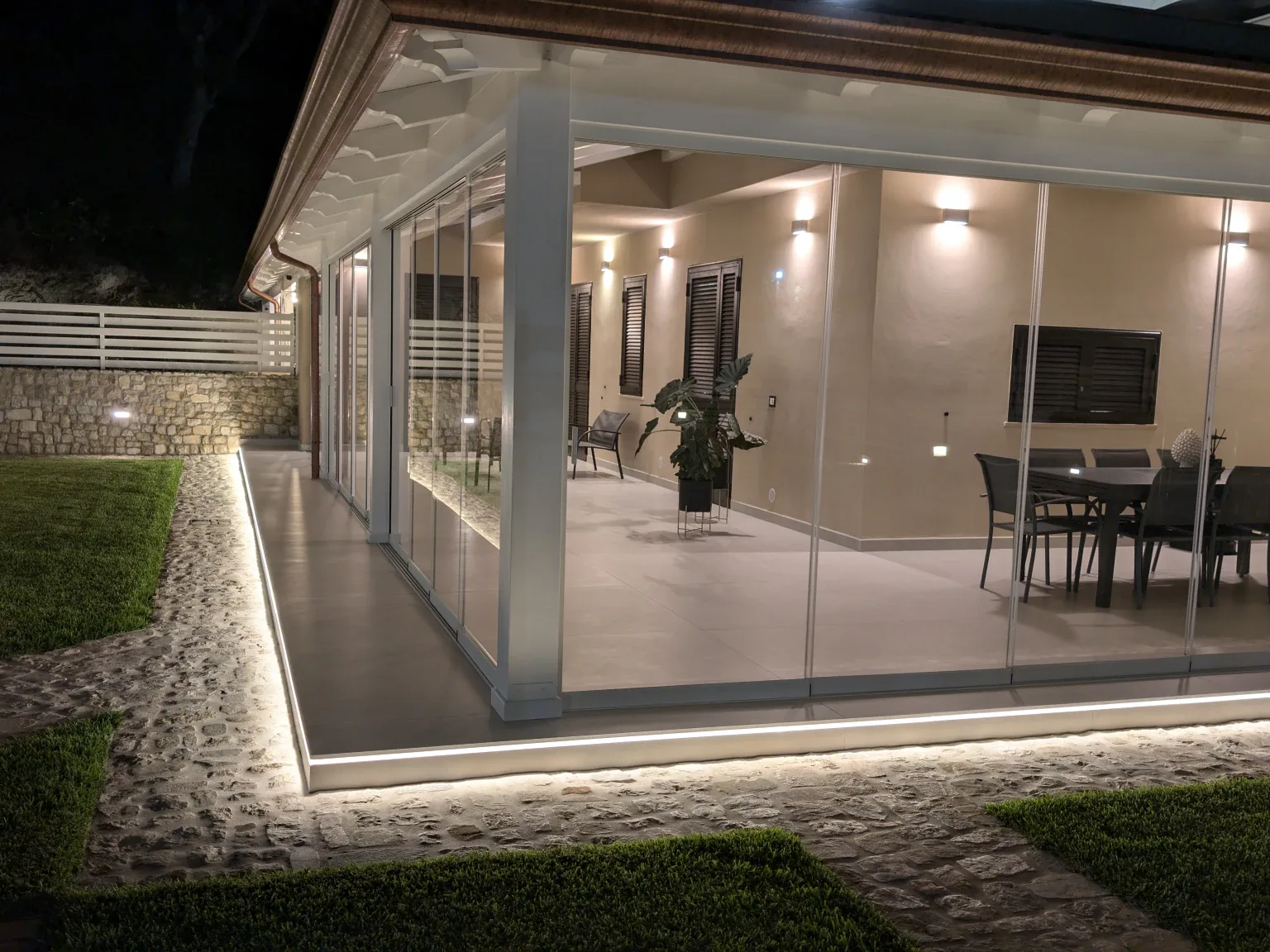 Sliding Floor lit at night, dining room seen from the garden